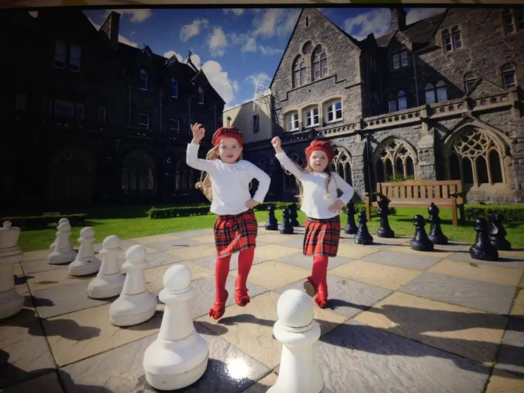 two young children playing with a giant chess set at Noble Apartment - Highland Club in Fort Augustus