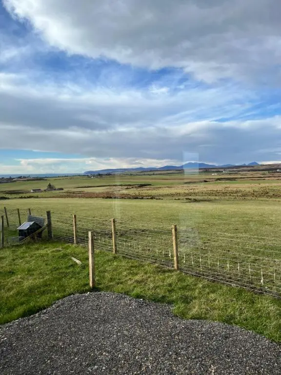 a fence in the middle of a field at Robyn\u2019s Nest in Lybster