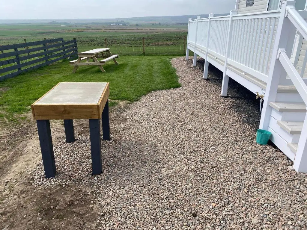 a wooden bench sitting on the side of a house at Robyn\u2019s Nest in Lybster