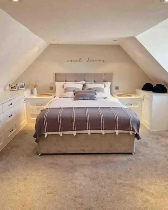 a bedroom with a large bed in an attic at Cullen Seaside Cottage in Cullen