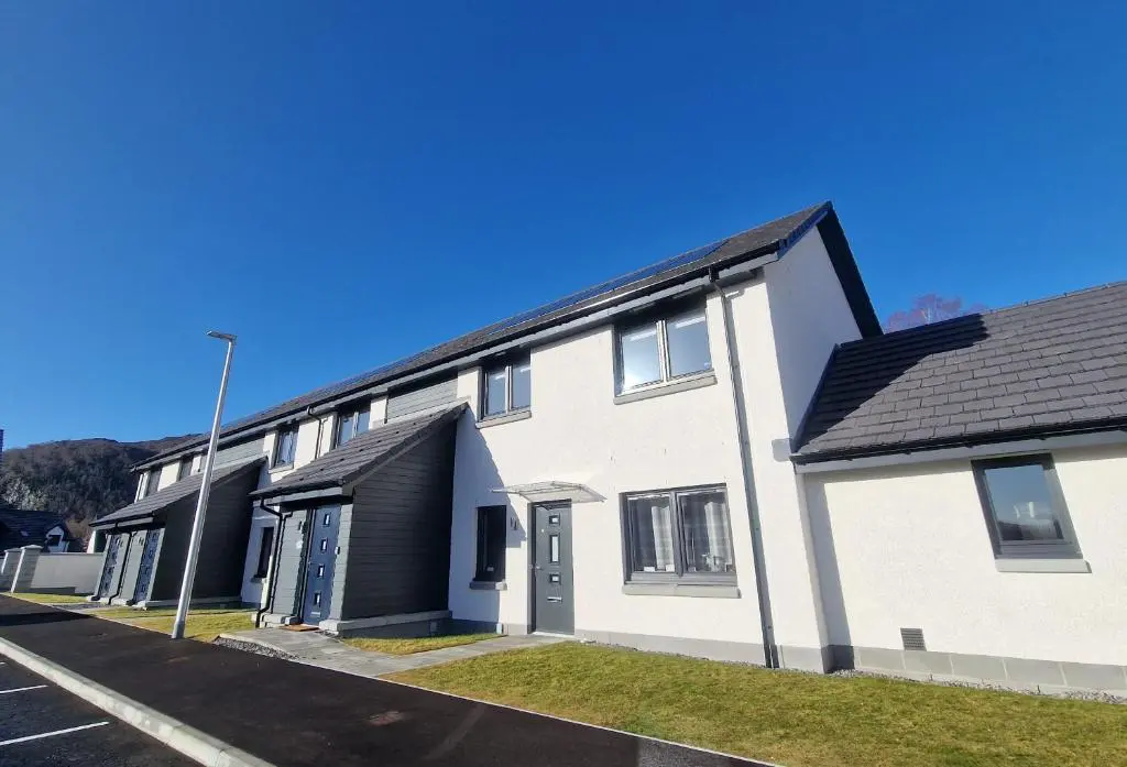 a white building with a black roof at 26 Ben Avon in Aviemore