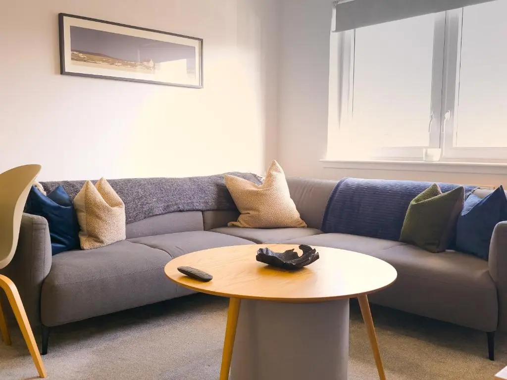 a living room with a couch and a table at 26 Ben Avon in Aviemore