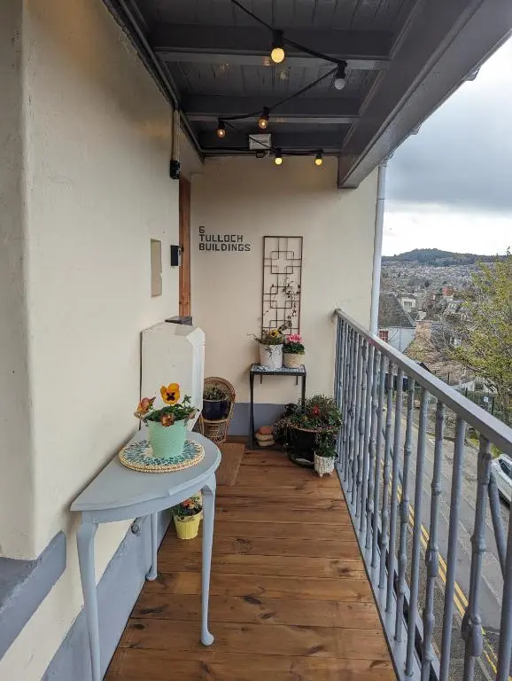 a balcony with a table and a refrigerator on it at Unique Highland in Inverness