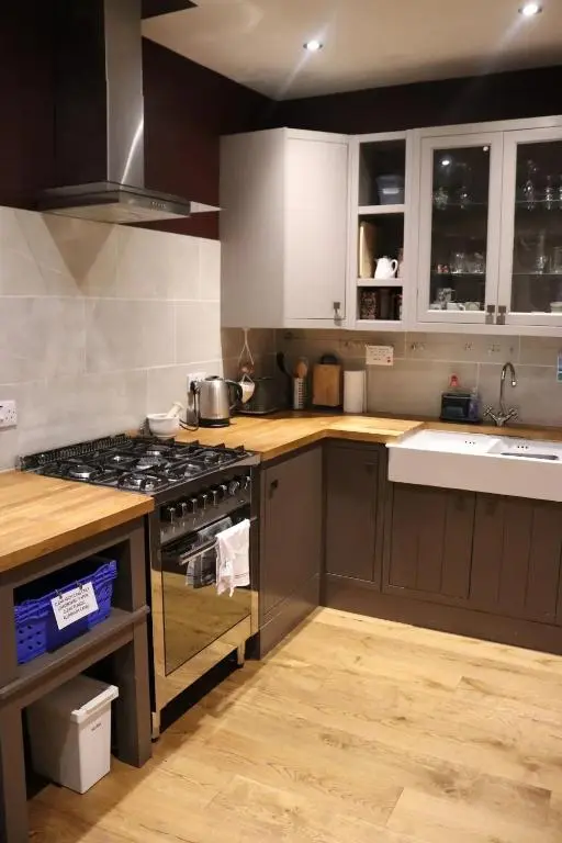 a kitchen with white cabinets and a stove top oven at Unique Highland in Inverness