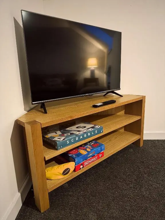 a flat screen tv on a wooden entertainment center at Firth View, Burghead in Burghead