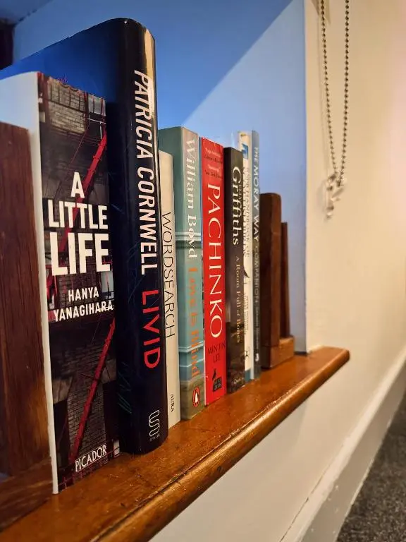 a row of books sitting on a shelf at Firth View, Burghead in Burghead