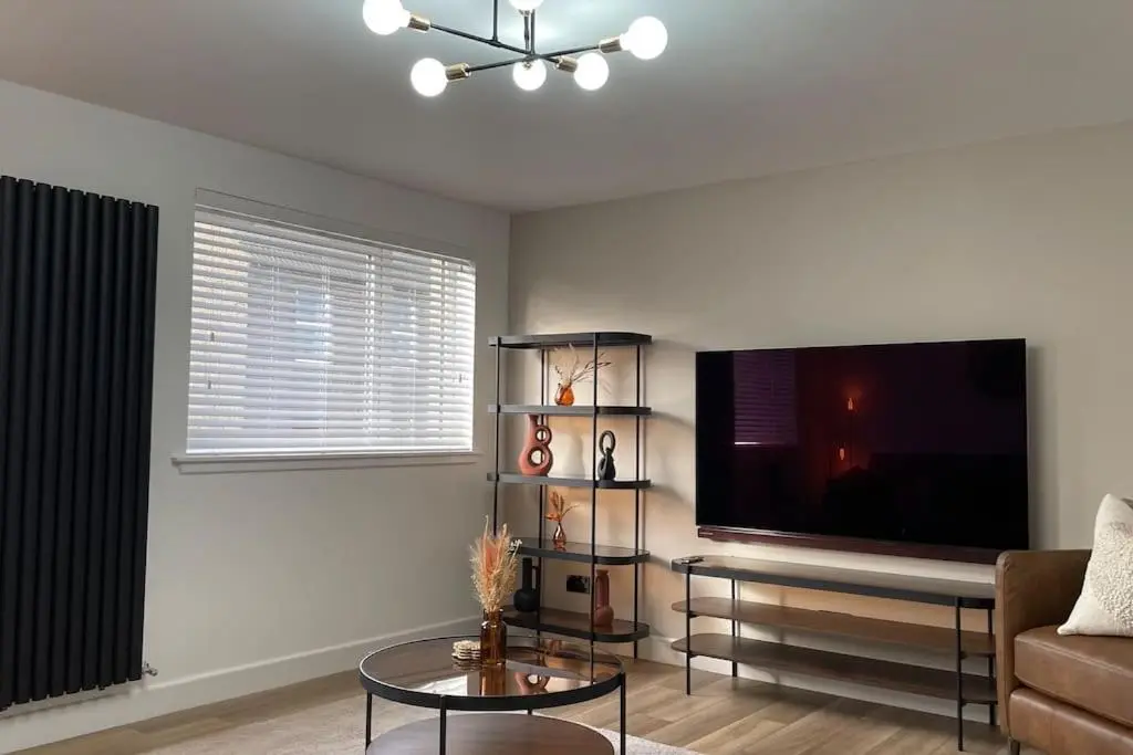 a living room with a couch and a flat screen tv at Braeview - by Caithness Luxury Apartments NC500 - 3 Bedroom Luxury holiday home - Sleeps Work teams upto 3 & holiday makers upto 5 in Wick
