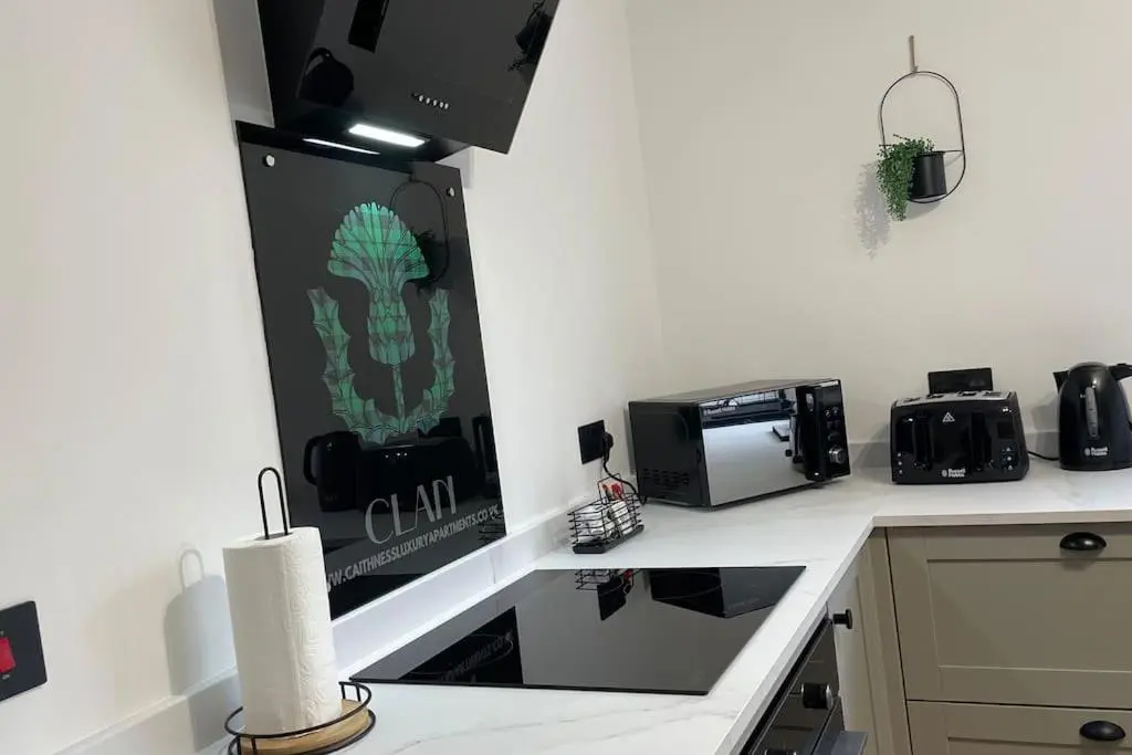 a kitchen with a counter with a toaster oven and a microwave at Braeview - by Caithness Luxury Apartments NC500 - 3 Bedroom Luxury holiday home - Sleeps Work teams upto 3 & holiday makers upto 5 in Wick