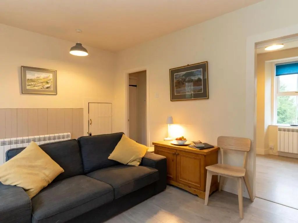 a living room with a couch and a chair at Holiday Home Railway House by Interhome in Aviemore