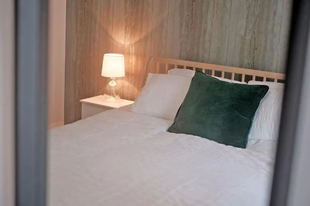 a bedroom with a white bed with a green pillow at Cliff Top Cottage with Sea Views in Portknockie