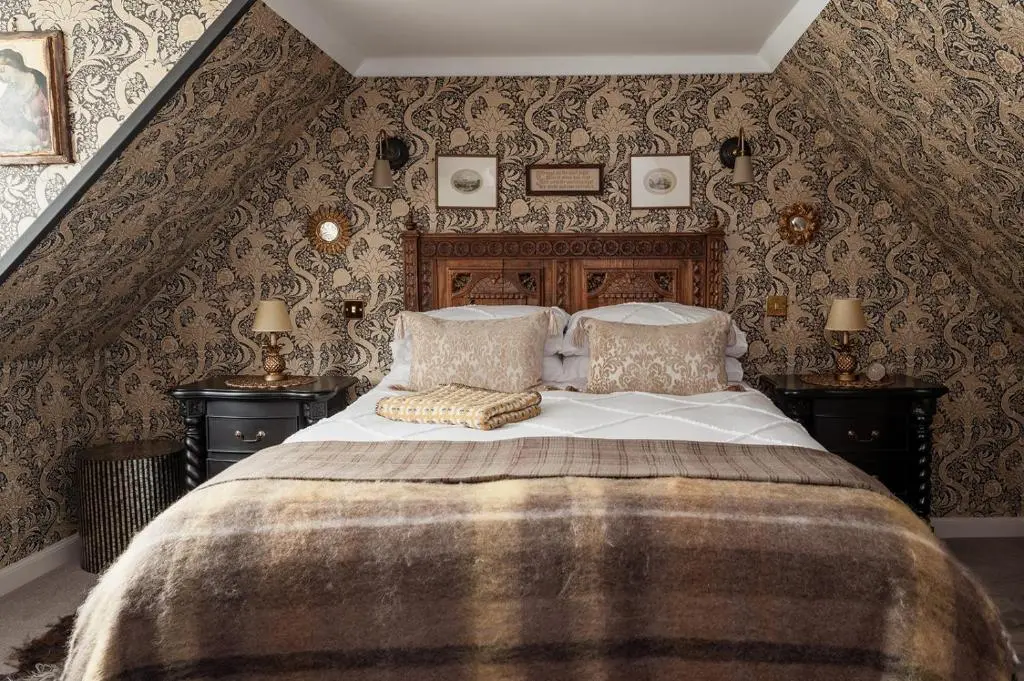 a bedroom with a large bed in a room with wallpaper at Luxury 3 Bedroom Cottage - Sleeps 6 in Tomintoul