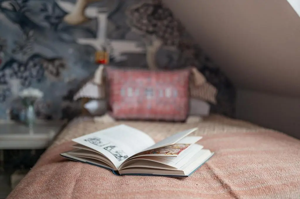 a book sitting on top of a bed at Luxury 3 Bedroom Cottage - Sleeps 6 in Tomintoul
