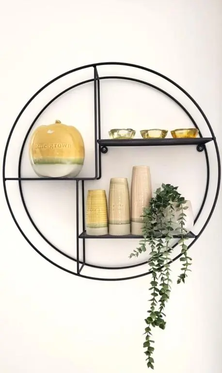 a metal ring shelf with gold coins and a plant at Insch House in Kincraig