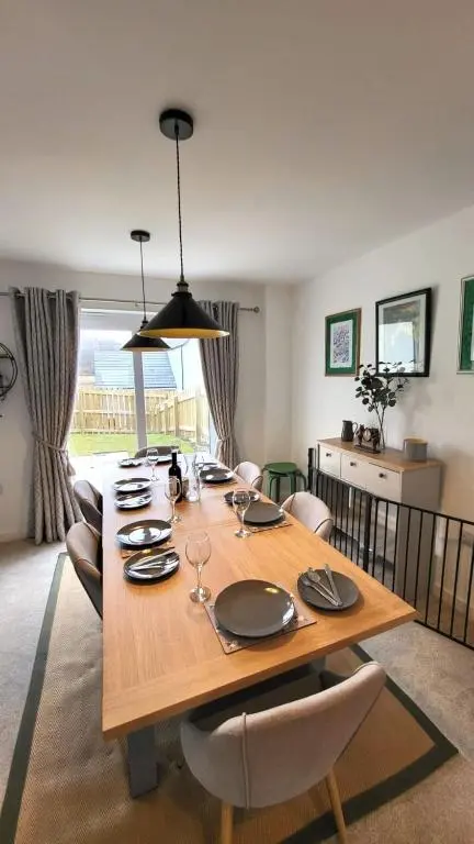 a dining room with a wooden table and chairs at Insch House in Kincraig