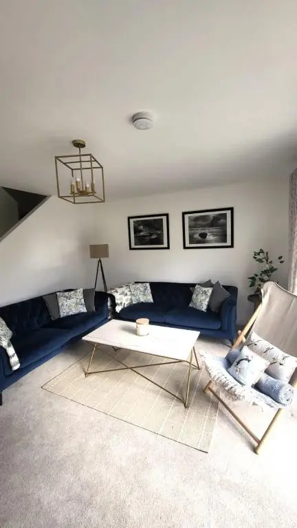 a living room with a blue couch and a table at Insch House in Kincraig