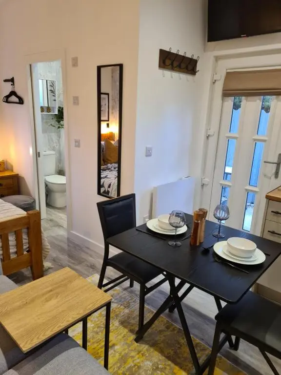 a living room with a black table and chairs at Findon nook in Culbokie