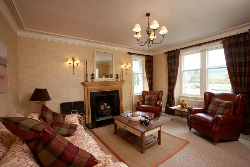 a living room with a couch and a fireplace at Ness Castle Lodges in Inverness
