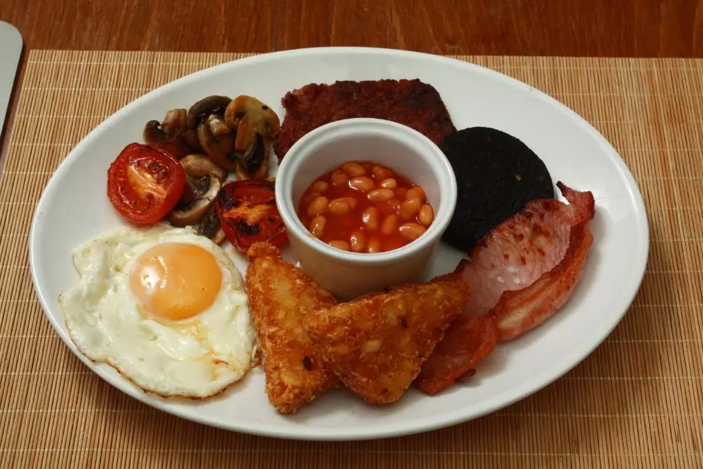 a plate of breakfast food with eggs bacon beans and mushrooms at The Retreat Hotel in Strathpeffer