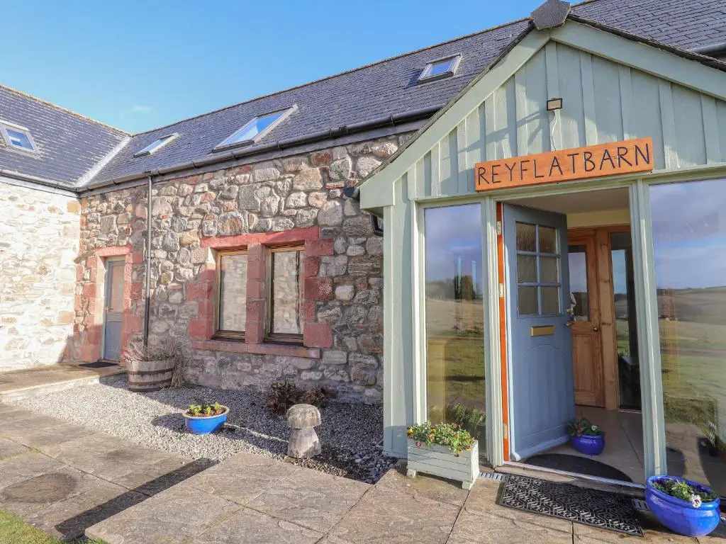 a stone building with a sign that reads reptilianarma at Reyflat Barn in Fortrose