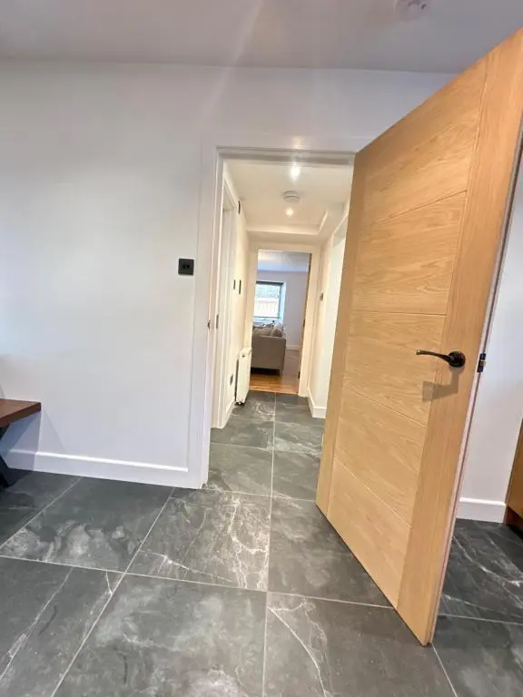 a hallway with a wooden door in a room at Smiddy Cottage Bauds in Buckie