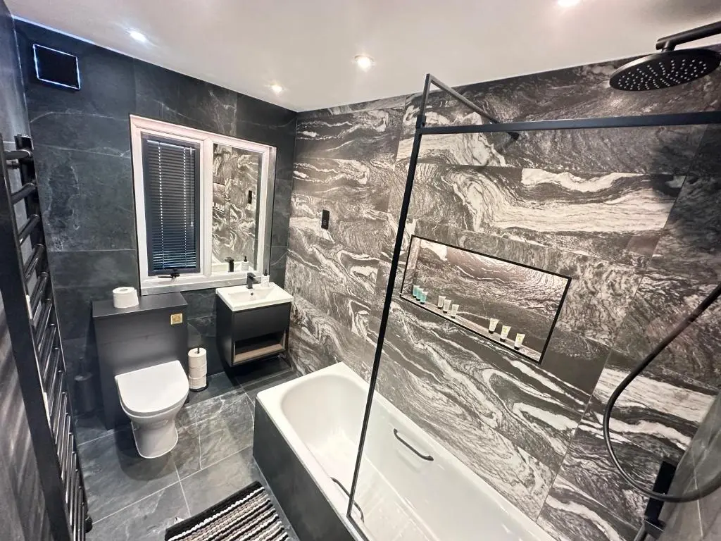 a bathroom with a tub and a toilet and a sink at Smiddy Cottage Bauds in Buckie