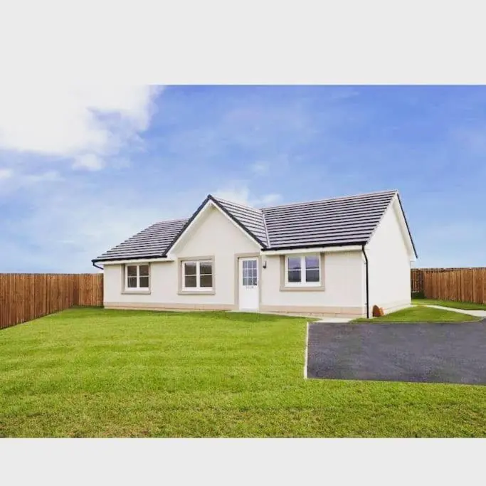 a small white house with a grassy yard at 3 bedroom detached house in Cononbridge