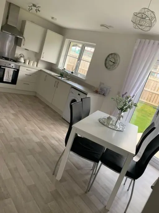 a kitchen with a white table and chairs in a room at 3 bedroom detached house in Cononbridge