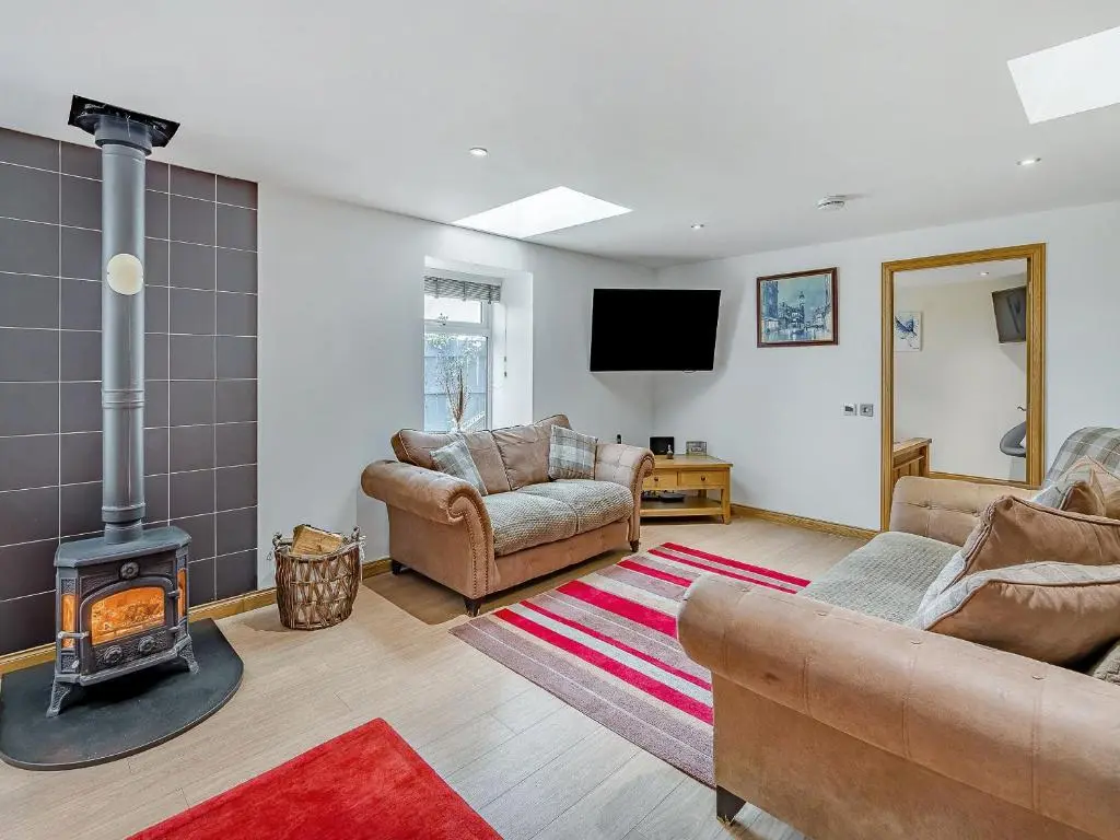 a living room with a wood stove in a room at Mains Of Durn Cottage, in Banff
