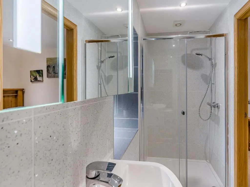 a bathroom with a shower and a sink at Mains Of Durn Cottage, in Banff
