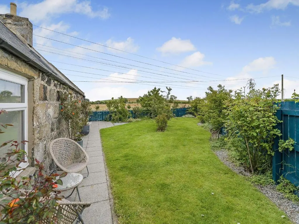 a garden with two chairs and a lawn at Mains Of Durn Cottage, in Banff