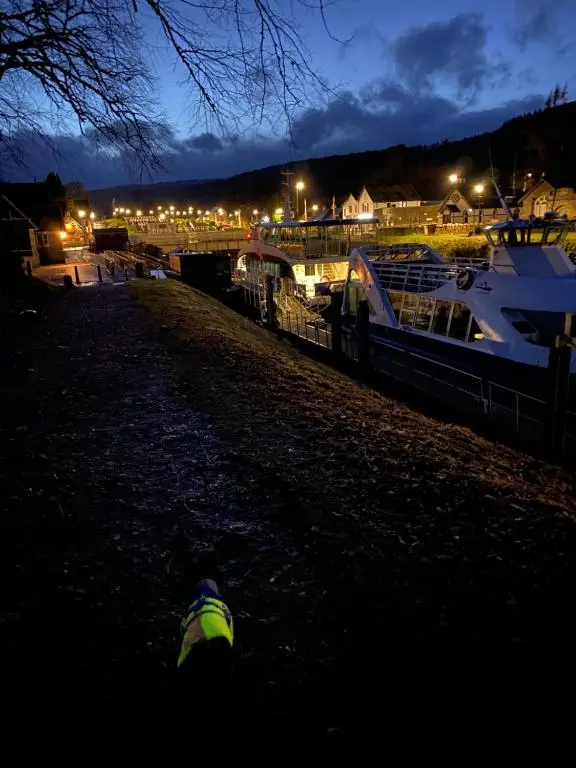 a boat is docked in a marina at night at Cameron apartment Loch Ness in Fort Augustus