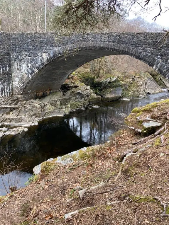 a stone bridge over a river with water underneath at Cameron apartment Loch Ness in Fort Augustus