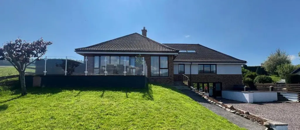 a house with a large lawn in front of it at Eldon Lea in Strathpeffer