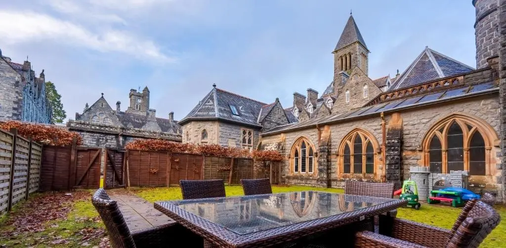 a courtyard of a castle with a table and chairs at Abbey Church 9 The Nave 2 bedroom Luxury Self catering apartment in Historic Abbey in Fort Augustus