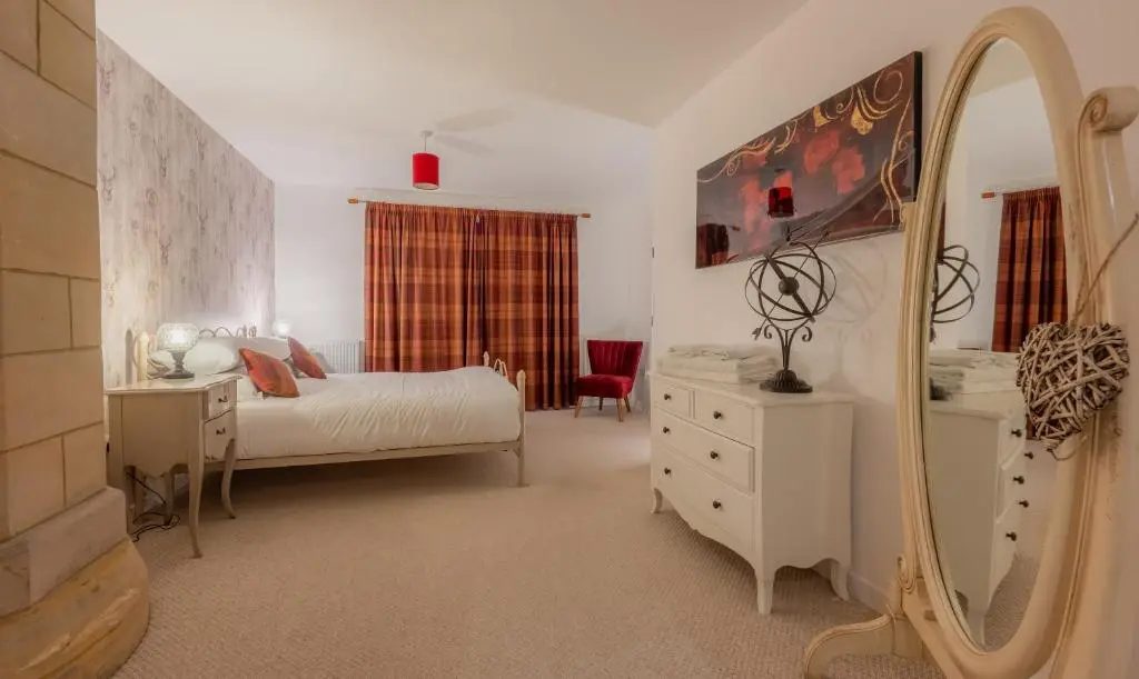 a bedroom with a bed and a mirror and a dresser at Abbey Church 9 The Nave 2 bedroom Luxury Self catering apartment in Historic Abbey in Fort Augustus