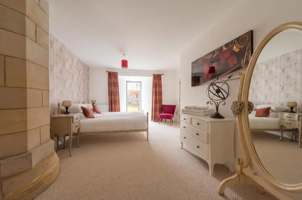 a bedroom with a bed and a mirror at Abbey Church 9 The Nave 2 bedroom Luxury Self catering apartment in Historic Abbey in Fort Augustus