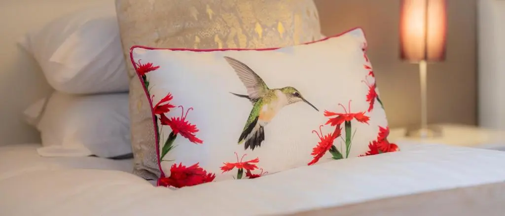 a humming bird on a pillow on a bed at AC19 Lower North Aisle - Luxury Self Catering 2 Bedroom Apartment in Fort Augustus