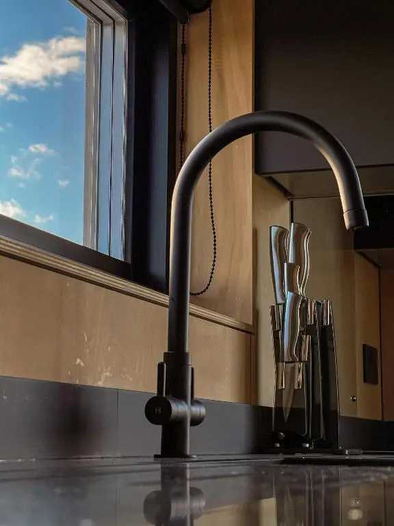a kitchen sink with a faucet next to a window at Tillyfruskie Farm Holiday Cabin, Finzean in Banchory