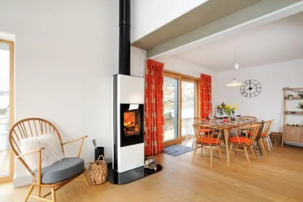 a living room with a fireplace and a table with chairs at Beautiful Lodge with hot tub & panoramic views in Boat of Garten
