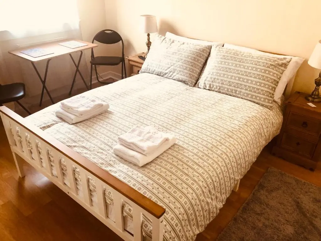 a bedroom with a bed with two towels on it at Inverthorn House in Inverness