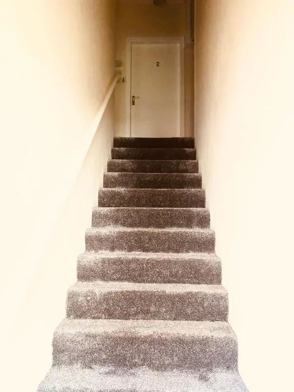 a stairway leading up to a white door at Inverthorn House in Inverness