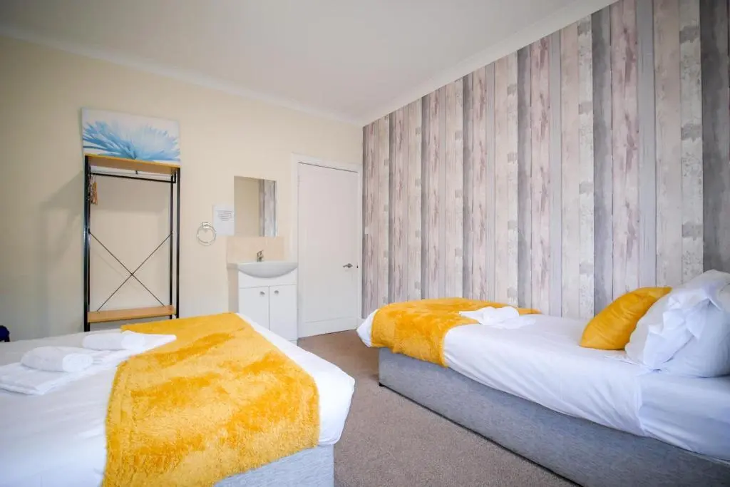 a hotel room with two beds and a mirror at Lochlash 3 Bedroom House Inverness in Inverness