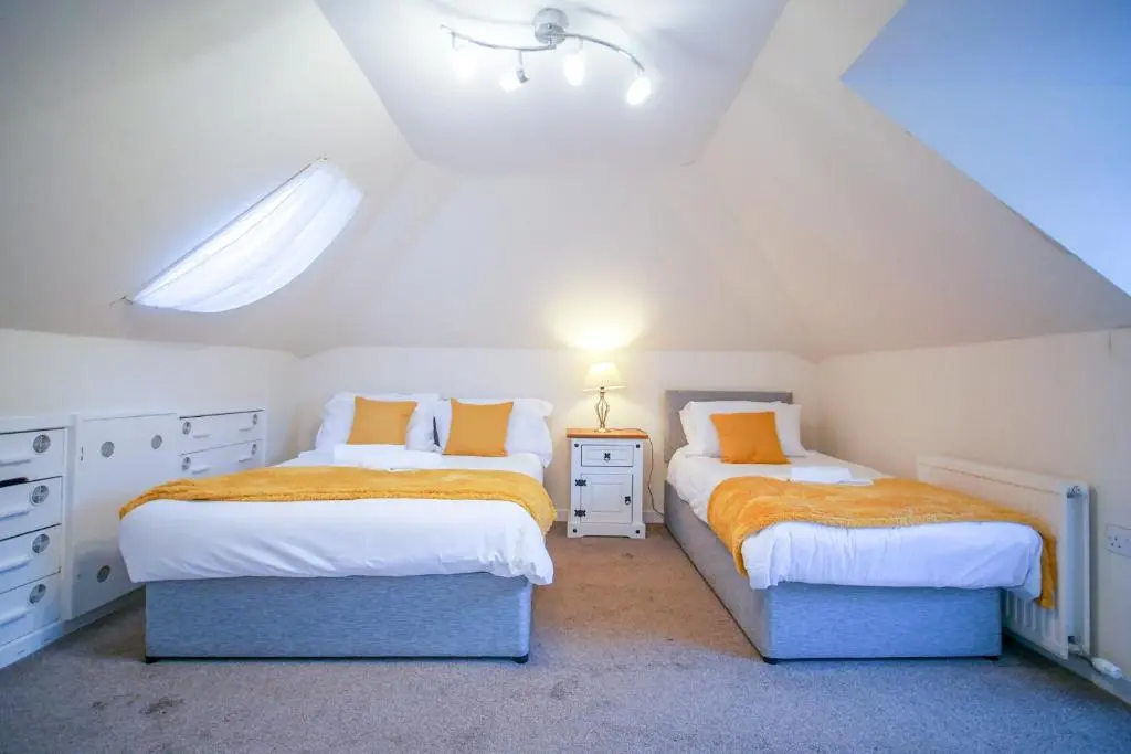 a attic bedroom with two beds and a window at Lochlash 3 Bedroom House Inverness in Inverness