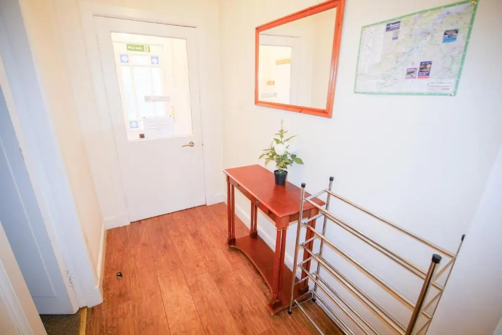 a stairway with a wooden table and a door at Lochlash 3 Bedroom House Inverness in Inverness
