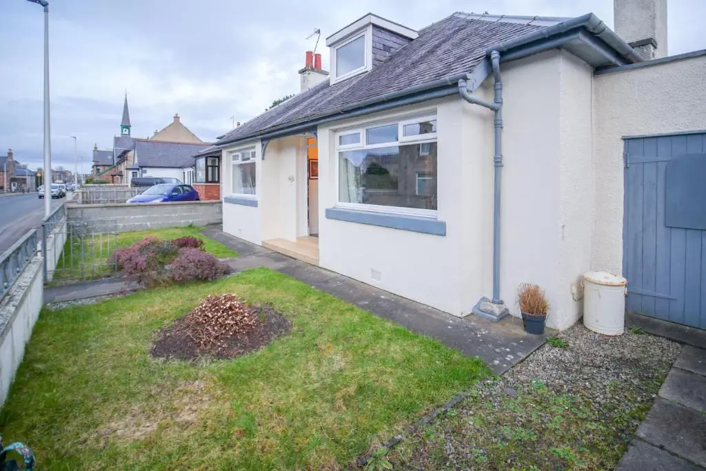 a white house with a yard in front of it at Lochlash 3 Bedroom House Inverness in Inverness