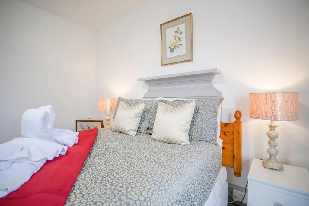 a bedroom with a bed with a red blanket and pillows at Telford Rd 5 Bedroom House Inverness in Inverness