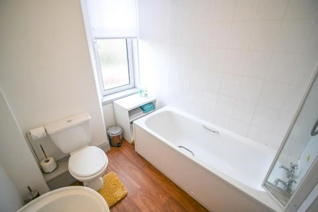 a white bathroom with a tub and a toilet at Telford Rd 5 Bedroom House Inverness in Inverness