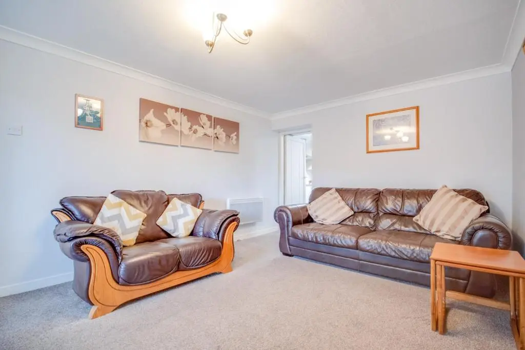 a living room with two leather couches and a table at Novar 4 Bedroom House Alness in Inverness