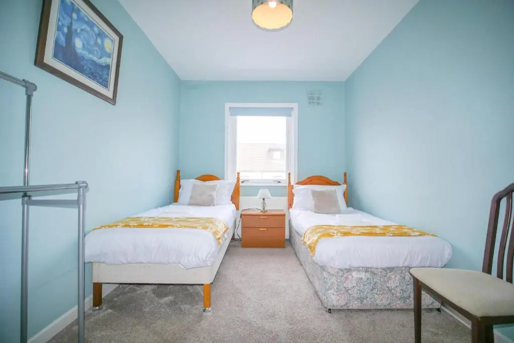 a blue room with two beds and a window at Telford St 4 Bedroom House Inverness in Inverness