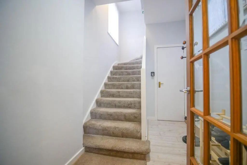 a staircase with white walls and a white door at Telford St 4 Bedroom House Inverness in Inverness